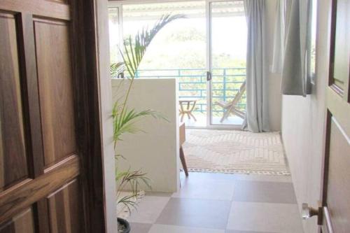 a hallway with a door and plants in a room at Boutique Tropical Retreat, Sleeps 10, Perfect for Friends and Fams in Sámara