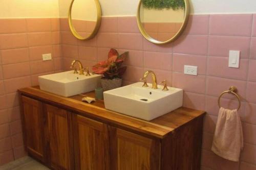a bathroom with two sinks and two mirrors at Boutique Tropical Retreat, Sleeps 10, Perfect for Friends and Fams in Sámara
