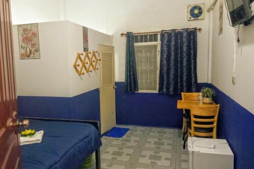 um quarto com uma cama, uma mesa e uma janela em Rene's Pasta Bar & Guesthouse em Koh Kong