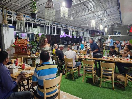 un groupe de personnes assises à table dans un restaurant dans l'établissement Rene's Pasta Bar & Guesthouse, à Koh Kong