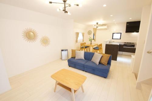 a living room with a blue couch and a table at FINOA Residential Suite Kameari in Tokyo