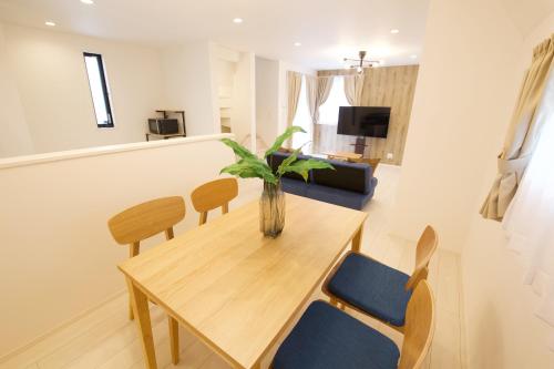a living room with a wooden table and chairs at FINOA Residential Suite Kameari in Tokyo