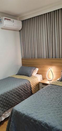 a hotel room with two beds and a window at Lindo apartamento no Litoral Norte in Camaçari