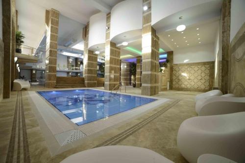a large swimming pool in a building with a lobby at Militari Luxury Flat in Roşu
