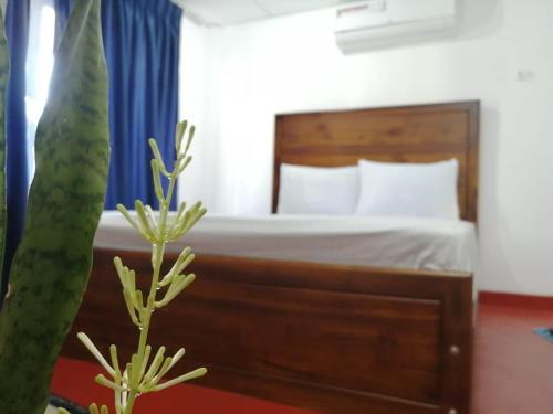 a bedroom with a bed with a blue curtain at Sagwa in Embilipitiya