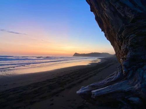 a view of a beach at sunset with a cliff at Boutique Tropical Retreat, Sleeps 10, Perfect for Friends and Fams in Sámara