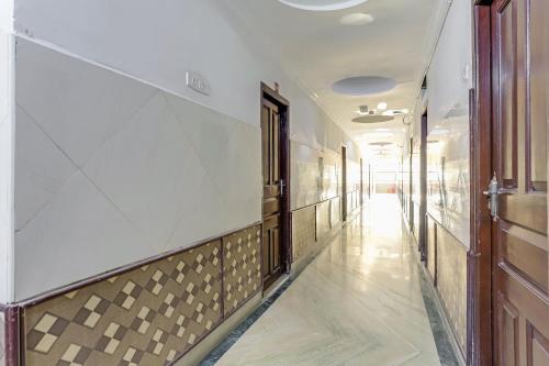 korytarz budynku z białymi ścianami i brązowymi drzwiami w obiekcie OYO Flagship Golden Manor w mieście Ćennaj