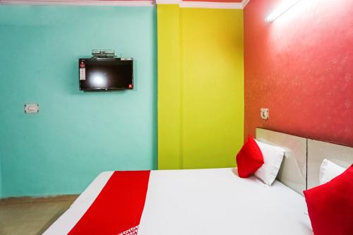 a bedroom with colorful walls and a bed with a tv at OYO Flagship Lotus Home Stay in New Delhi