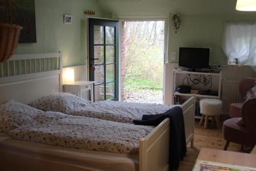 a bedroom with two beds and a living room at Ferienhof Spiegelhaus in Krummhörn
