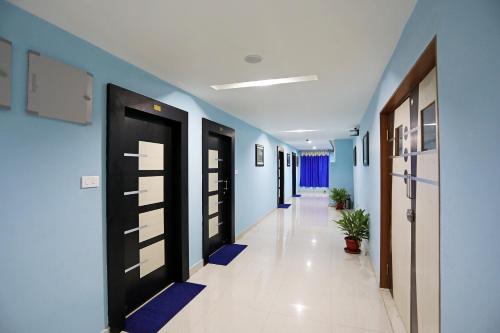 un pasillo con paredes azules y puertas negras en Sai Swastik, en Bhubaneshwar