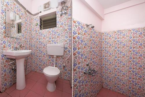a bathroom with a toilet and a sink at Super Hotel O Sai Swastik in Bhubaneshwar