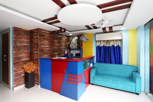 a colorful lobby with a woman sitting at a counter at Sai Swastik in Bhubaneshwar