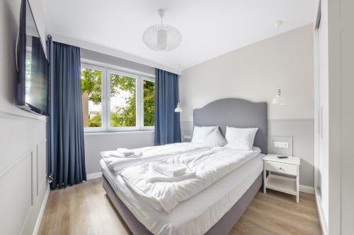 une chambre avec un grand lit et une télévision dans l'établissement Kubacza, Sun & Snow, à Sopot