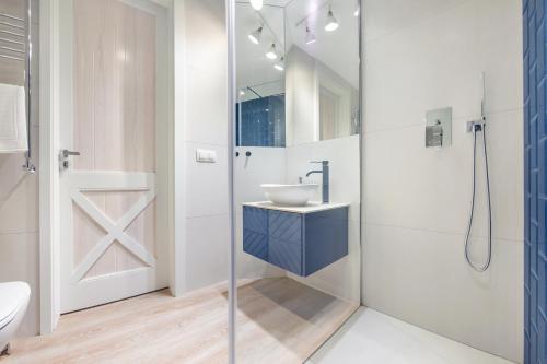 uma casa de banho com um lavatório e um chuveiro em Apartamenty Sun & Snow Kubacza em Sopot