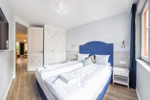 a large bed with a blue headboard in a bedroom at Apartamenty Sun & Snow Kubacza in Sopot