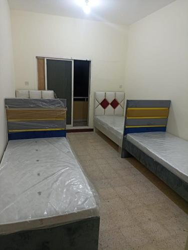 a room with two beds in a room at NuZee Hostel for Girls only in Dubai