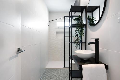 Un baño blanco con lavabo y espejo. en Ula Home, en Barbate