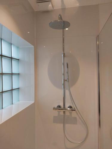 a shower with a shower head in a bathroom at Repos St Elisabeth nabij Plopsaland in De Panne