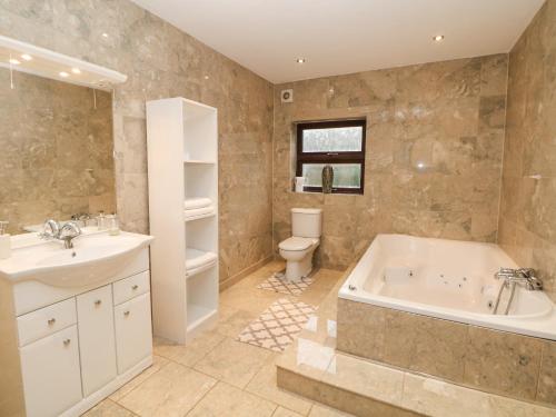 uma casa de banho com uma banheira, um WC e um lavatório. em The House at The Sitwell Arms em Sheffield