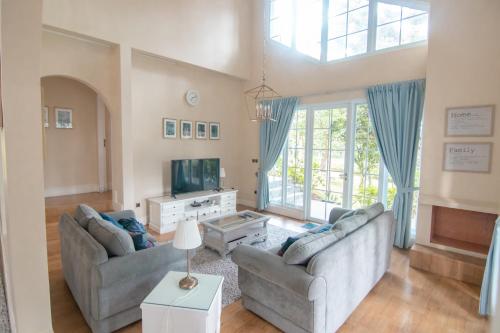 a living room with two couches and a tv at Harvest Mountain Farm Guesthouse in Bogor