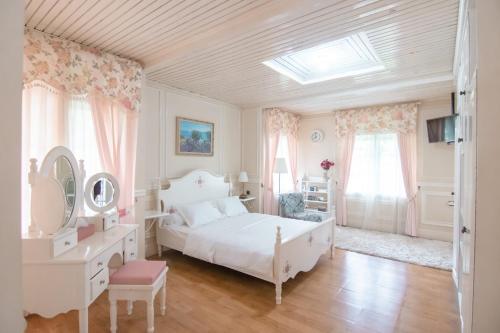 a white bedroom with a bed and a skylight at Harvest Mountain Farm Guesthouse in Bogor