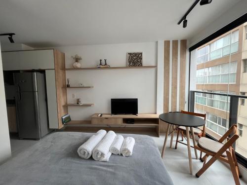 um quarto com uma cama e uma mesa com toalhas em Studio Minimalista em São Paulo