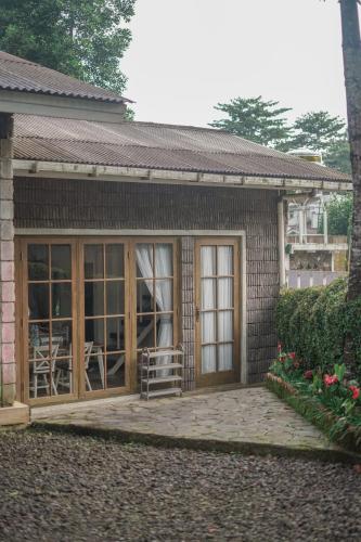 a small house with a large sliding glass door at Harvest Mountain Farm Guesthouse in Bogor