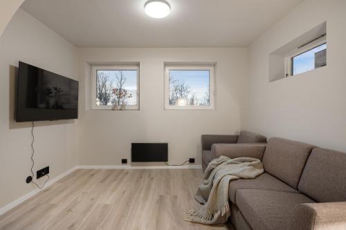 a living room with a couch and a flat screen tv at Enter Tromsø - 3 Bedroom Home in Tromsø