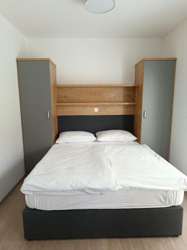 a bed with white sheets and pillows in a room at Guesthouse Haler in Podčetrtek