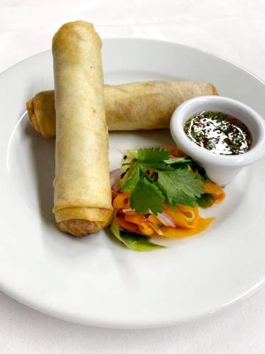 a white plate with a sandwich and a roll and sauce at The Glenbeigh Hotel in Glenbeigh