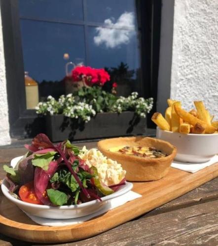 a table with two plates of food and french fries at The Glenbeigh Hotel in Glenbeigh