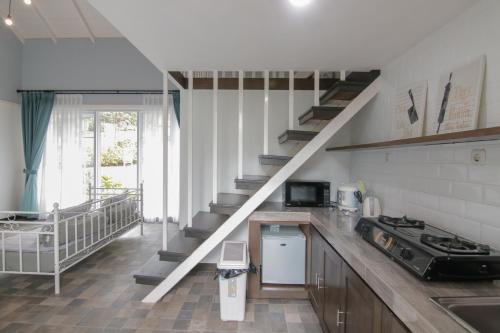 a kitchen with a spiral staircase in a house at Harvest Mountain Farm Guesthouse in Bogor