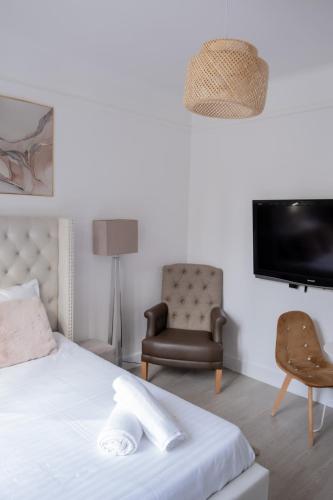 - une chambre avec un lit, une chaise et une télévision dans l'établissement Résidence Peace, au Bourget