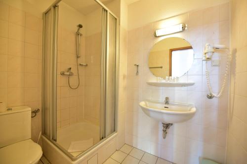 a bathroom with a shower toilet and a sink at Hotel Meereseck in Bansin