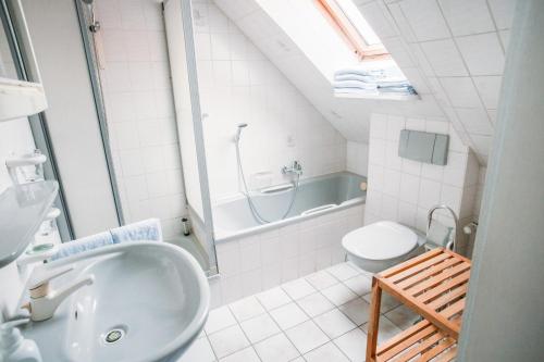 ein Badezimmer mit einem Waschbecken, einem WC und einer Badewanne in der Unterkunft Hotel Zum König von Griechenland in Ovelgönne