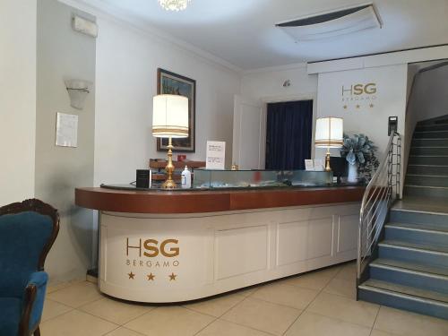 a hotel lobby with a reception desk and stairs at Hotel San Giorgio in Bergamo
