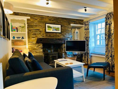 a living room with a couch and a fireplace at Gill Cottage, The Gill. in Ulverston