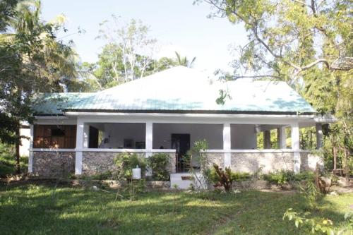 a white house with a green roof at JozaniBiospherevillage in Jozani