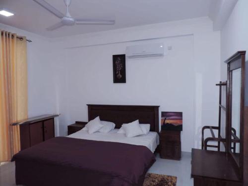 a bedroom with a large bed and a chair at SEA BREEZE HOLIDAYS HOME in Colombo