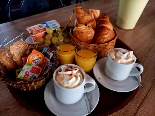 a tray with two cups of coffee and a basket of bread at Hotel Restaurant Le Costabonne in Prats-de-Mollo-la-Preste