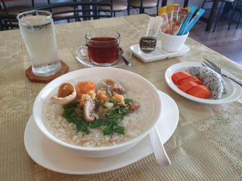 a bowl of rice with mushrooms and vegetables on a table at Kireeya Villa in Phetchaburi