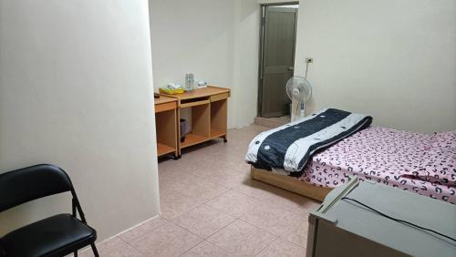 a bedroom with a bed and a desk and a chair at 頭城旅宿 in Toucheng