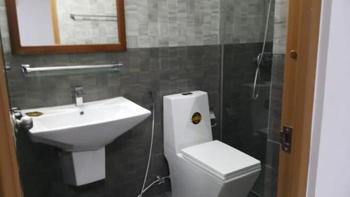 a bathroom with a sink and a toilet and a mirror at SEA BREEZE HOLIDAYS HOME in Colombo