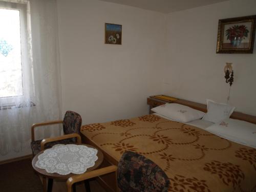 a room with a bed and a table and chairs at Apartman Nena in Klenovica