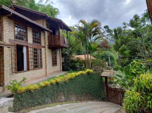 a house with a balcony and a fence at Casa de Campo in Nova Friburgo