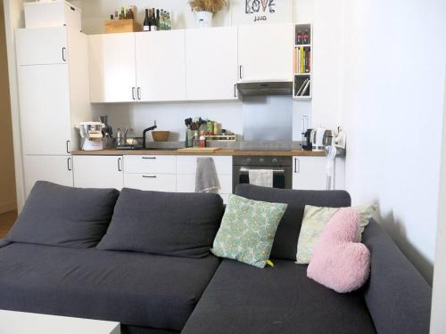 - un canapé bleu avec des oreillers dans la cuisine dans l'établissement Petit Vinaigriers République CityCosy, à Paris