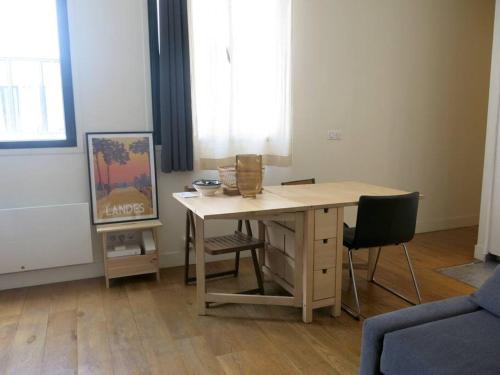 - un bureau dans une chambre avec une table et des chaises dans l'établissement Petit Vinaigriers République CityCosy, à Paris
