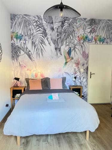 1 dormitorio con 1 cama grande y papel pintado tropical en Chambre tropicale privée au coeur d'un village calme et proche du vignoble, en Vinzelles