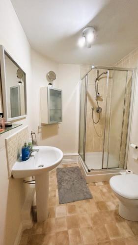 a bathroom with a shower and a sink and a toilet at Ensuite Double Bedroom in a 2 bed Spacious Apartment in Warrington