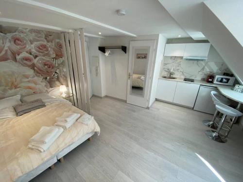 - une chambre avec un grand lit orné de roses sur le mur dans l'établissement Esprit Romantique, à Mulhouse